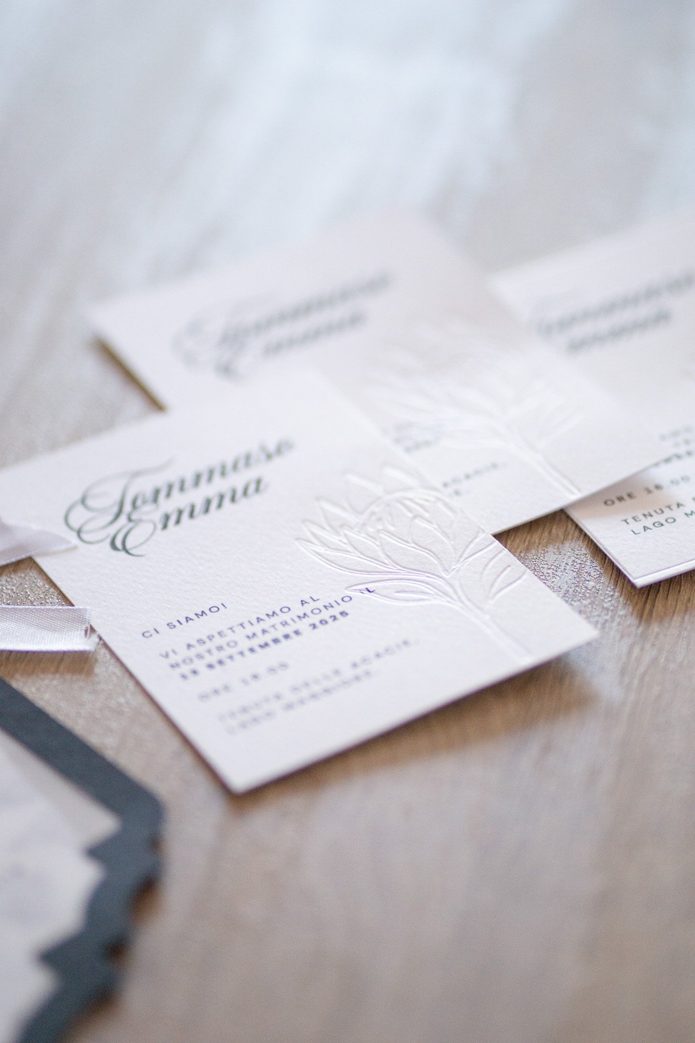Dettaglio artigianale di una scritta calligrafica bianca su cartoncino arancione, simbolo del lavoro creativo e manuale del Craft Studio Graphoenicks.

