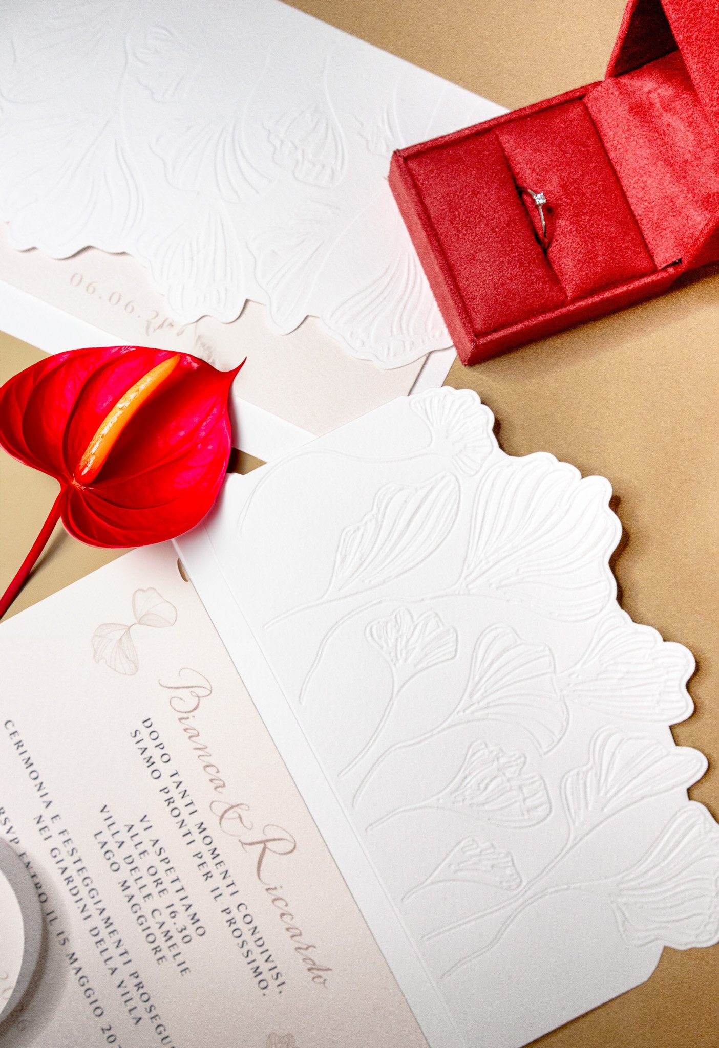 Invito personalizzato per evento con nastro in raso rosso e stampa su carta di pregio.